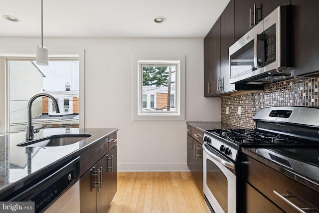 315 Dupont St, Philadelphia, PA 19128 - kitchen featuring stainless steel appliances, decorative backsplash, dark stone countertops, light wood finished floors, and recessed lighting