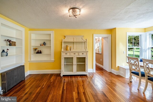 1148 Bodine Rd, Chester Springs, PA 19425 - dining room with radiator, a textured ceiling, baseboards, wood-type flooring, and built in features