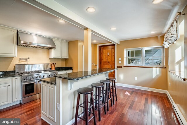 1148 Bodine Rd, Chester Springs, PA 19425 - kitchen featuring wall chimney range hood, double oven range, a baseboard heating unit, baseboards, and dark wood finished floors