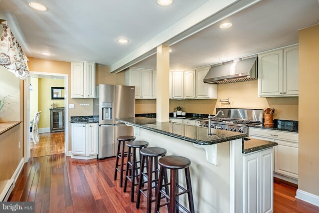 1148 Bodine Rd, Chester Springs, PA 19425 - kitchen with stainless steel fridge with ice dispenser, wall chimney exhaust hood, stove, dark wood finished floors, and dark stone countertops