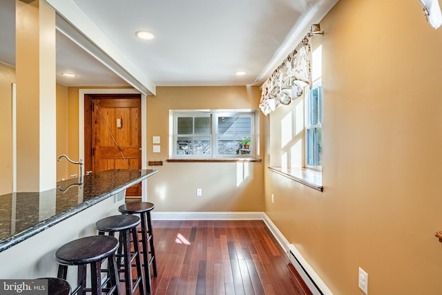 1148 Bodine Rd, Chester Springs, PA 19425 - interior space with dark wood finished floors, dark stone countertops, baseboards, a kitchen bar, and a baseboard heating unit