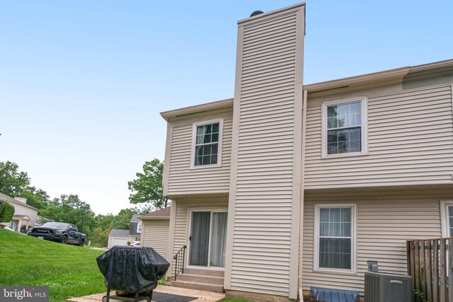 5941 Powells Landing Rd, Burke, VA 22015 - back of property featuring entry steps, a chimney, central air condition unit, and a lawn