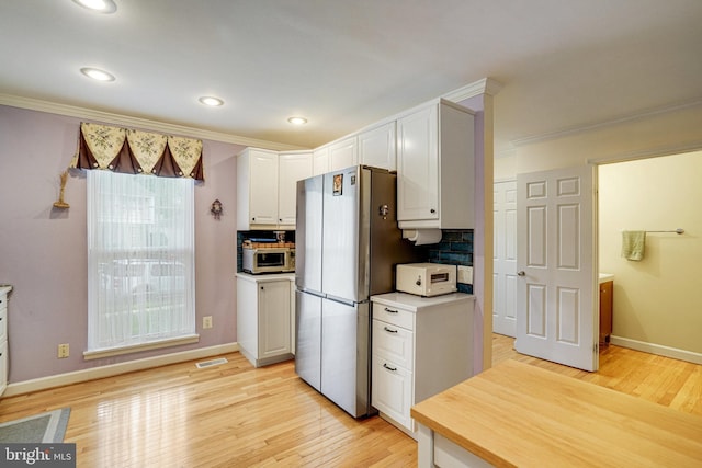 5941 Powells Landing Rd, Burke, VA 22015 - kitchen featuring freestanding refrigerator, white cabinets, ornamental molding, light wood-style floors, and white microwave