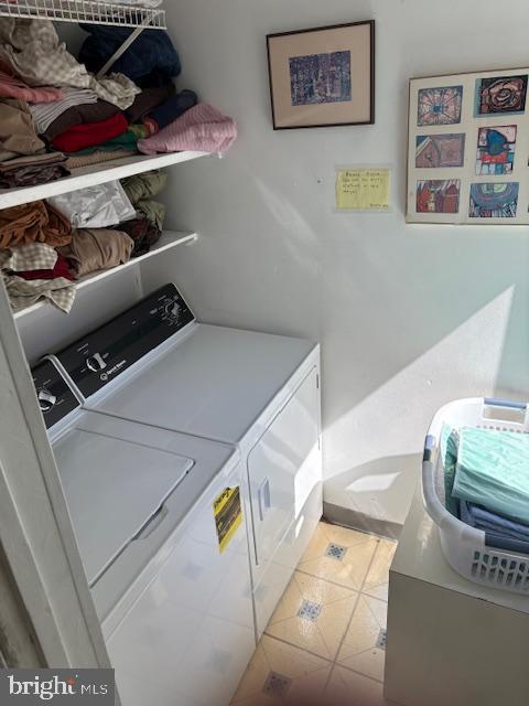 laundry room with washing machine and clothes dryer and tile patterned flooring