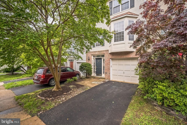 9435 Silver Meteor Ct, Manassas Park, VA 20111 - townhome / multi-family property featuring brick siding, asphalt driveway, and an attached garage