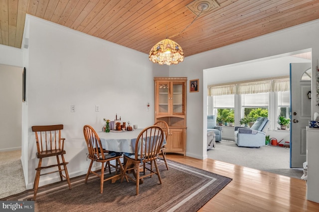 7466 Beebe Rd, Chincoteague Island, VA 23336 - dining space with wood ceiling, crown molding, wood finished floors, and baseboards