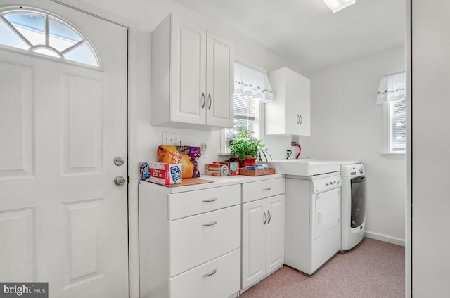 7466 Beebe Rd, Chincoteague Island, VA 23336 - kitchen with washing machine and clothes dryer, light countertops, healthy amount of natural light, and white cabinets