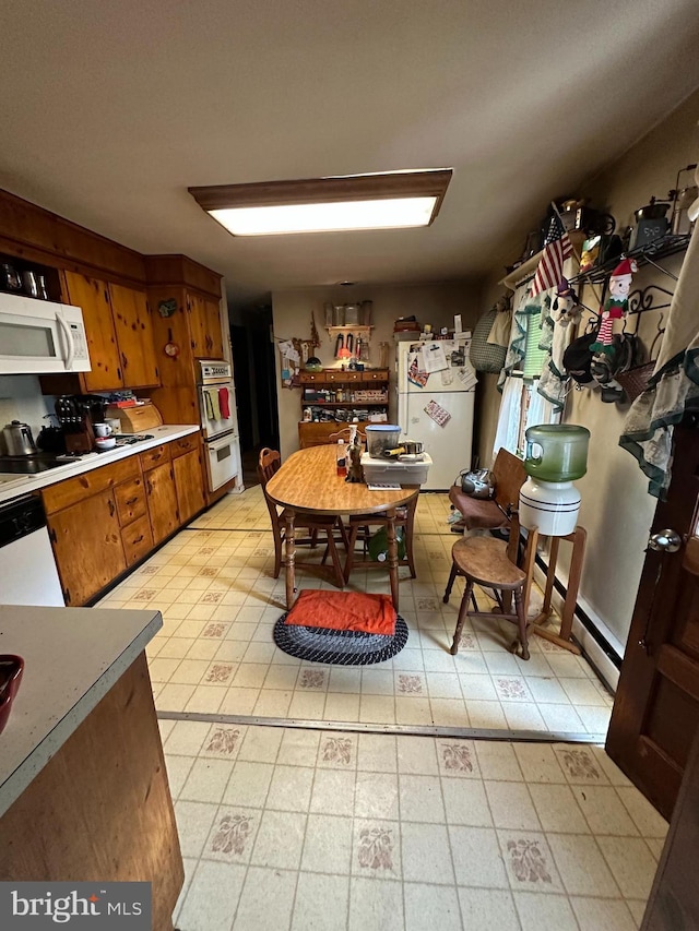 kitchen with white appliances, brown cabinets, light countertops, and light flooring