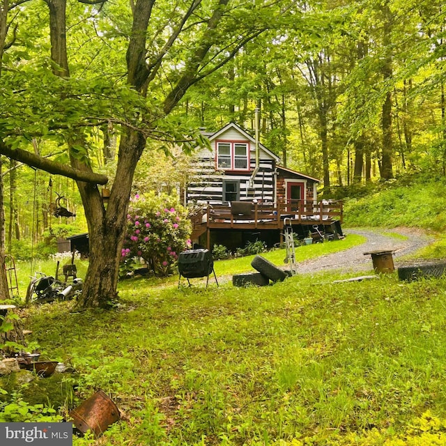 view of yard featuring a deck and a view of trees