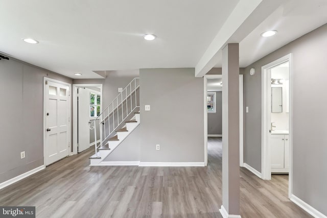 entryway featuring wood finished floors, baseboards, recessed lighting, and stairs