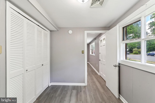 hallway featuring wood finished floors and baseboards