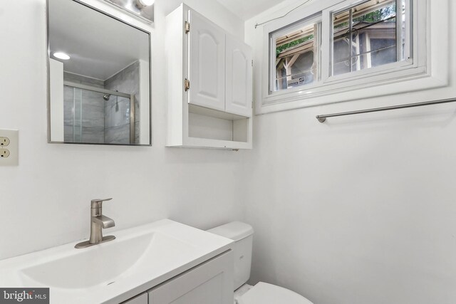full bath with toilet, a shower with door, and vanity