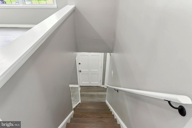 stairs with wood finished floors and baseboards