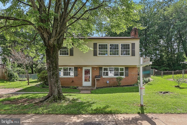 view of front of home with a chimney and brick siding