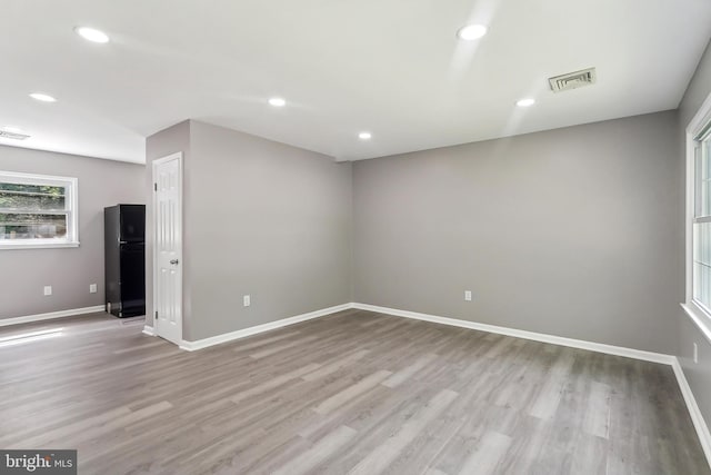unfurnished room featuring baseboards, light wood-type flooring, and recessed lighting