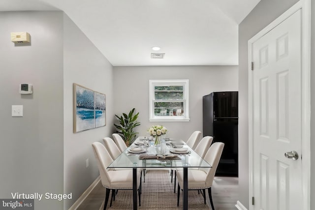 dining area with baseboards and wood finished floors