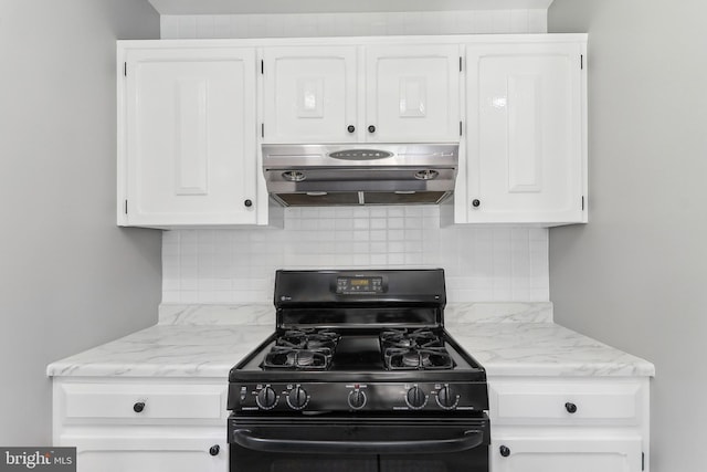 kitchen with gas stove, exhaust hood, white cabinetry, decorative backsplash, and light stone counters