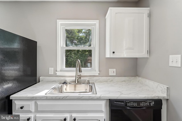 kitchen with black appliances, a sink, white cabinets, and light stone countertops