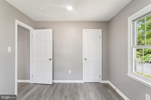 unfurnished bedroom featuring wood finished floors, baseboards, and recessed lighting