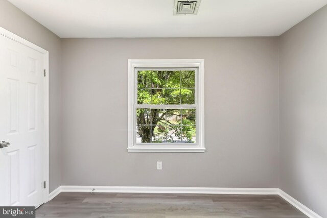 spare room with wood finished floors and baseboards