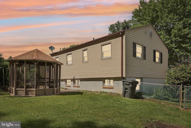 back of house with a gazebo, a sunroom, and an attached garage