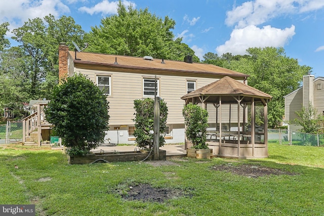 back of house with a gazebo and a chimney