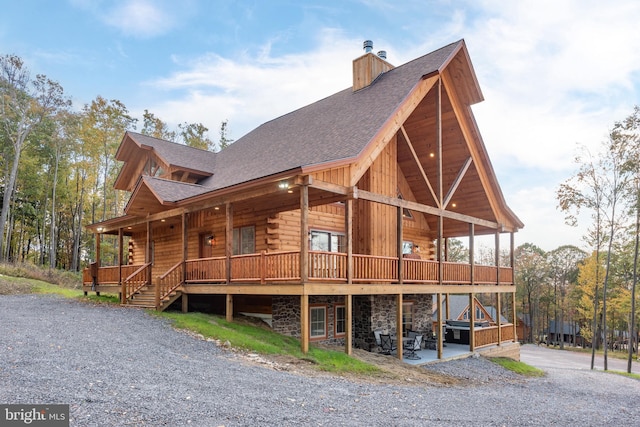 view of side of home featuring a shingled roof, a chimney, and log exterior