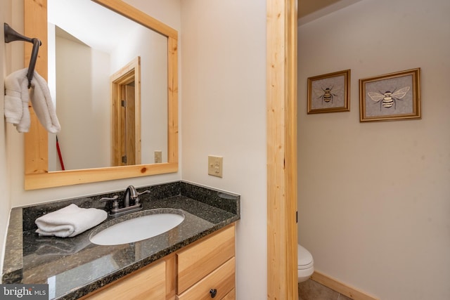 half bath featuring toilet, vanity, and tile patterned flooring