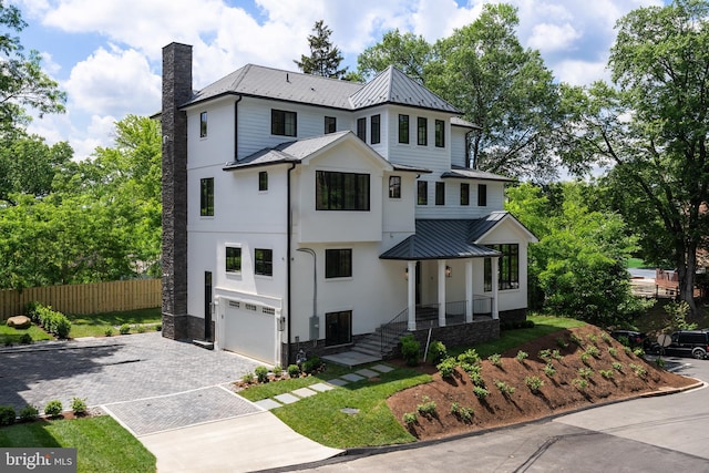 5024 Dana Pl NW, Washington, DC 20016 - view of front of property with a chimney, fence, a standing seam roof, decorative driveway, and a garage