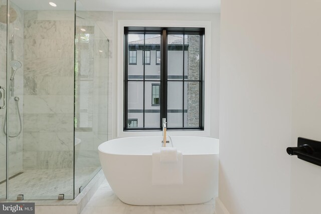 5024 Dana Pl NW, Washington, DC 20016 - full bathroom featuring a shower stall, a soaking tub, and baseboards