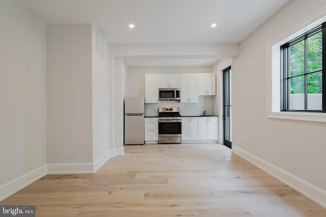5024 Dana Pl NW, Washington, DC 20016 - kitchen featuring stainless steel appliances, white cabinetry, light wood-type flooring, dark countertops, and recessed lighting