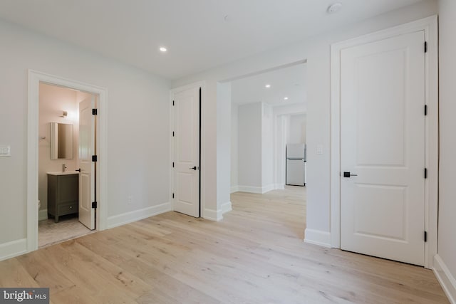 5024 Dana Pl NW, Washington, DC 20016 - unfurnished bedroom featuring freestanding refrigerator, light wood-style floors, baseboards, recessed lighting, and connected bathroom