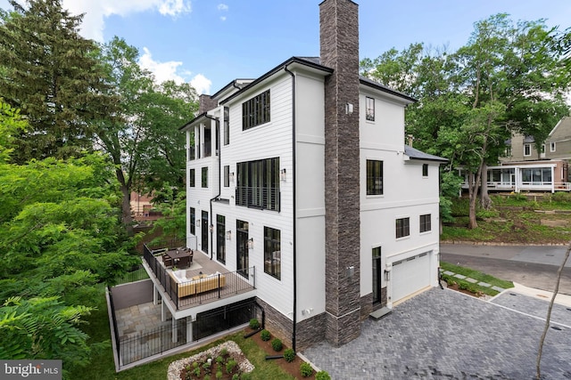 5024 Dana Pl NW, Washington, DC 20016 - back of house with a chimney, a garage, and decorative driveway