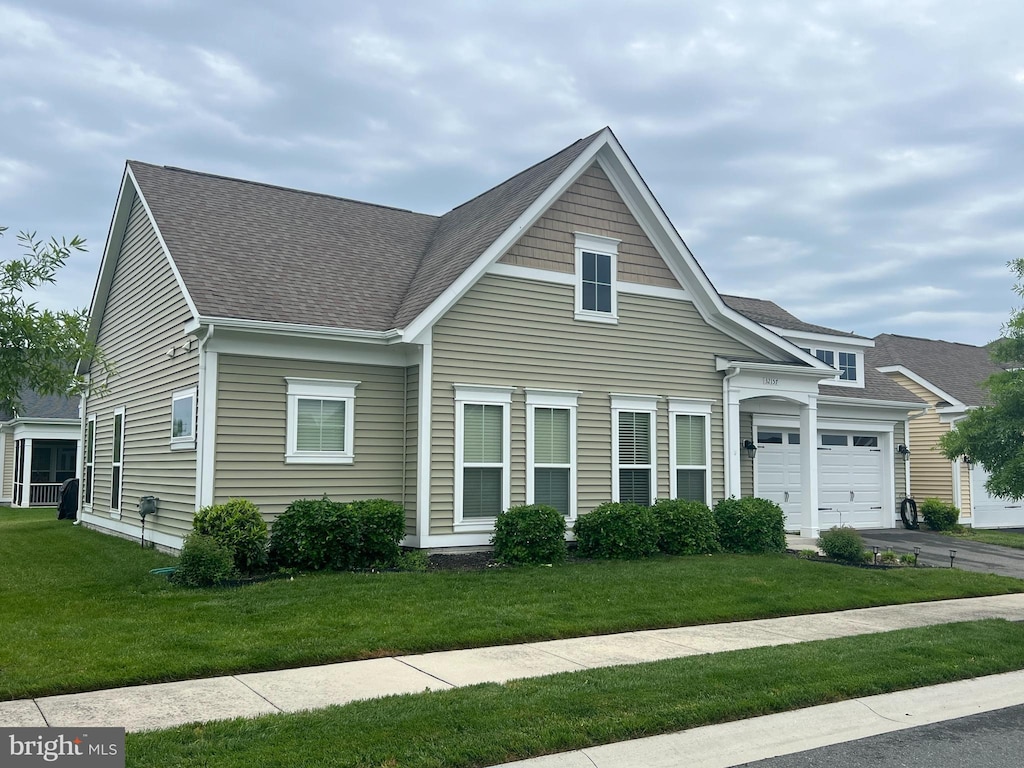 32157 Shorebreak Xing, Millville, DE 19967 - view of front of house featuring an attached garage, a shingled roof, a front lawn, and asphalt driveway