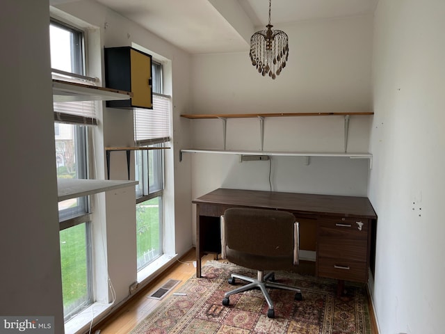 unfurnished office featuring a chandelier and wood finished floors