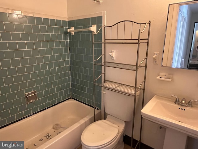 bathroom with toilet, shower / washtub combination, and a sink