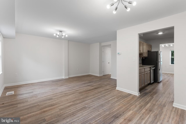 662 W Side Dr Unit 1-H, Gaithersburg, MD 20878 - unfurnished living room with a chandelier, light wood-type flooring, and baseboards