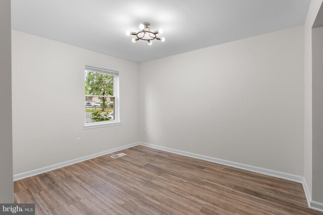 662 W Side Dr Unit 1-H, Gaithersburg, MD 20878 - unfurnished room featuring a chandelier, wood finished floors, and baseboards