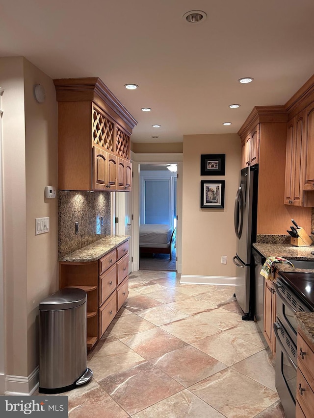 kitchen featuring freestanding refrigerator, baseboards, stone counters, range with two ovens, and recessed lighting