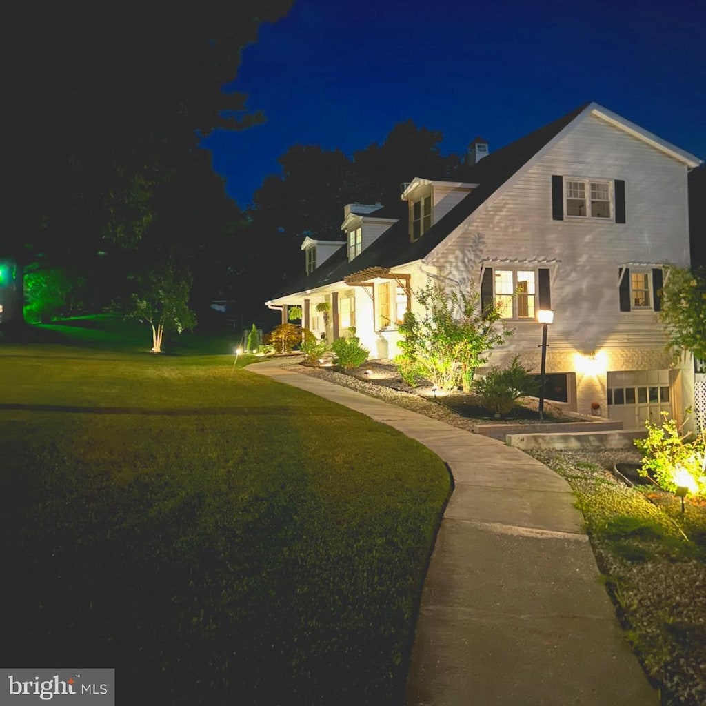 property exterior at twilight with a lawn and a garage