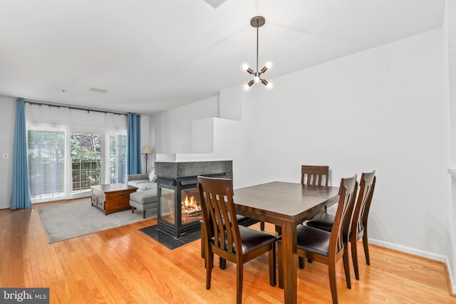 1510 Northern Neck Dr Unit 102, Vienna, VA 22182 - dining area featuring light wood-style flooring, a multi sided fireplace, and baseboards