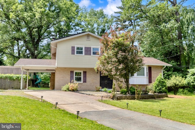 tri-level home with brick siding, a carport, and concrete driveway