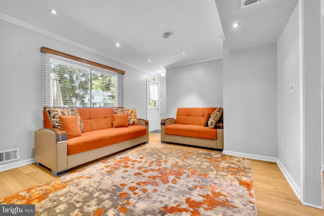 living area featuring wood finished floors, baseboards, crown molding, and recessed lighting