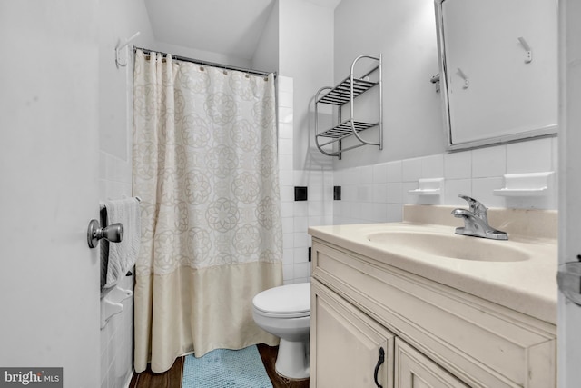 bathroom with tile walls, toilet, vanity, a shower with curtain, and wainscoting