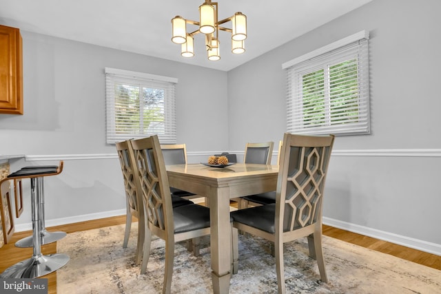dining room featuring a chandelier, light wood-style flooring, and plenty of natural light