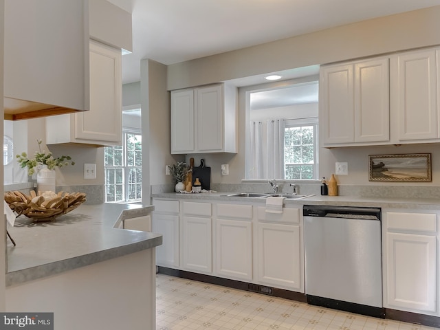 kitchen with dishwasher, a sink, white cabinets, and light flooring