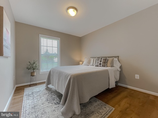 bedroom with light wood-type flooring and baseboards