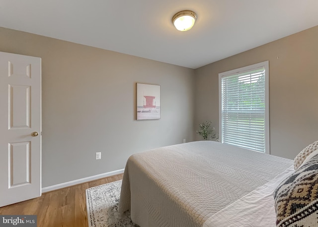 bedroom with light wood finished floors and baseboards