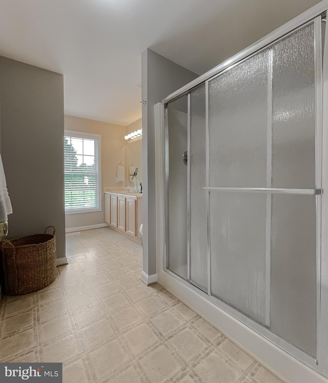full bathroom featuring a shower stall, vanity, tile patterned floors, and baseboards