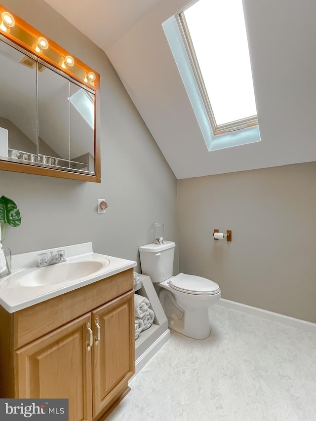 half bathroom with lofted ceiling, a skylight, toilet, and vanity